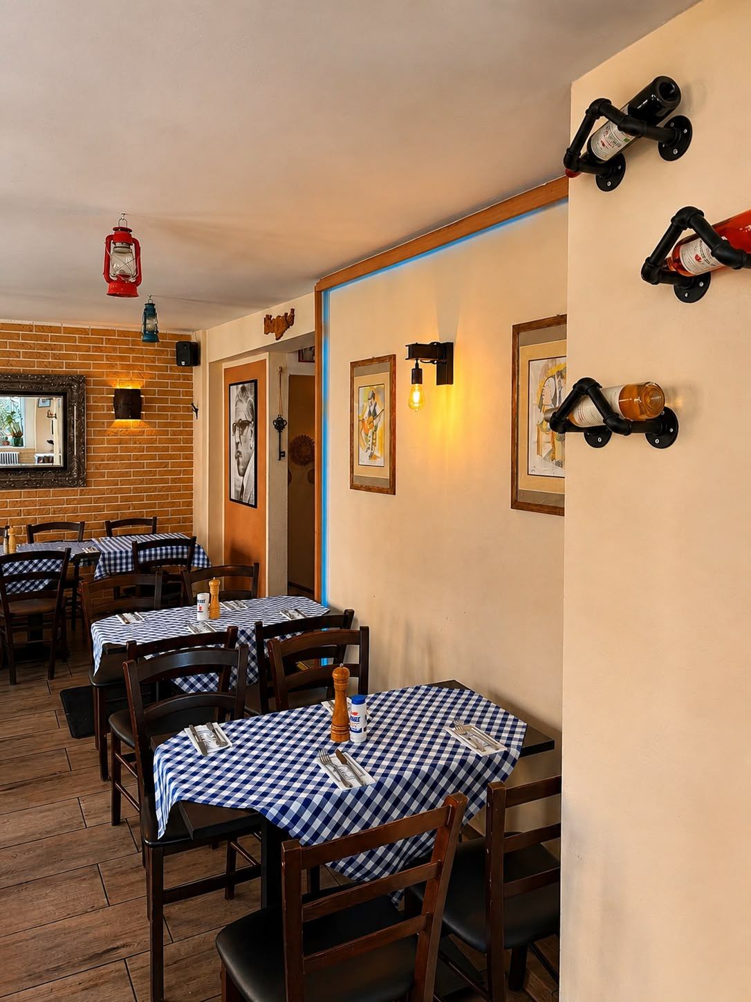 Gastraum der Taverna Teloneio mit blau-karierten Tischen und Backsteinwand